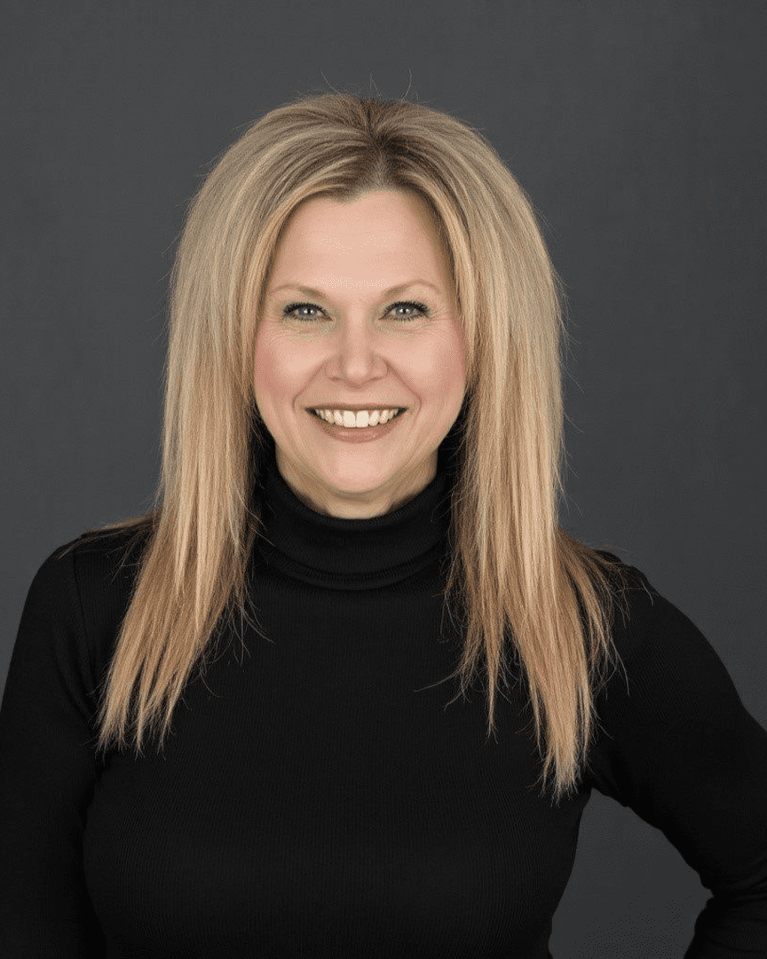 Smiling woman with long blonde hair in a black turtleneck.