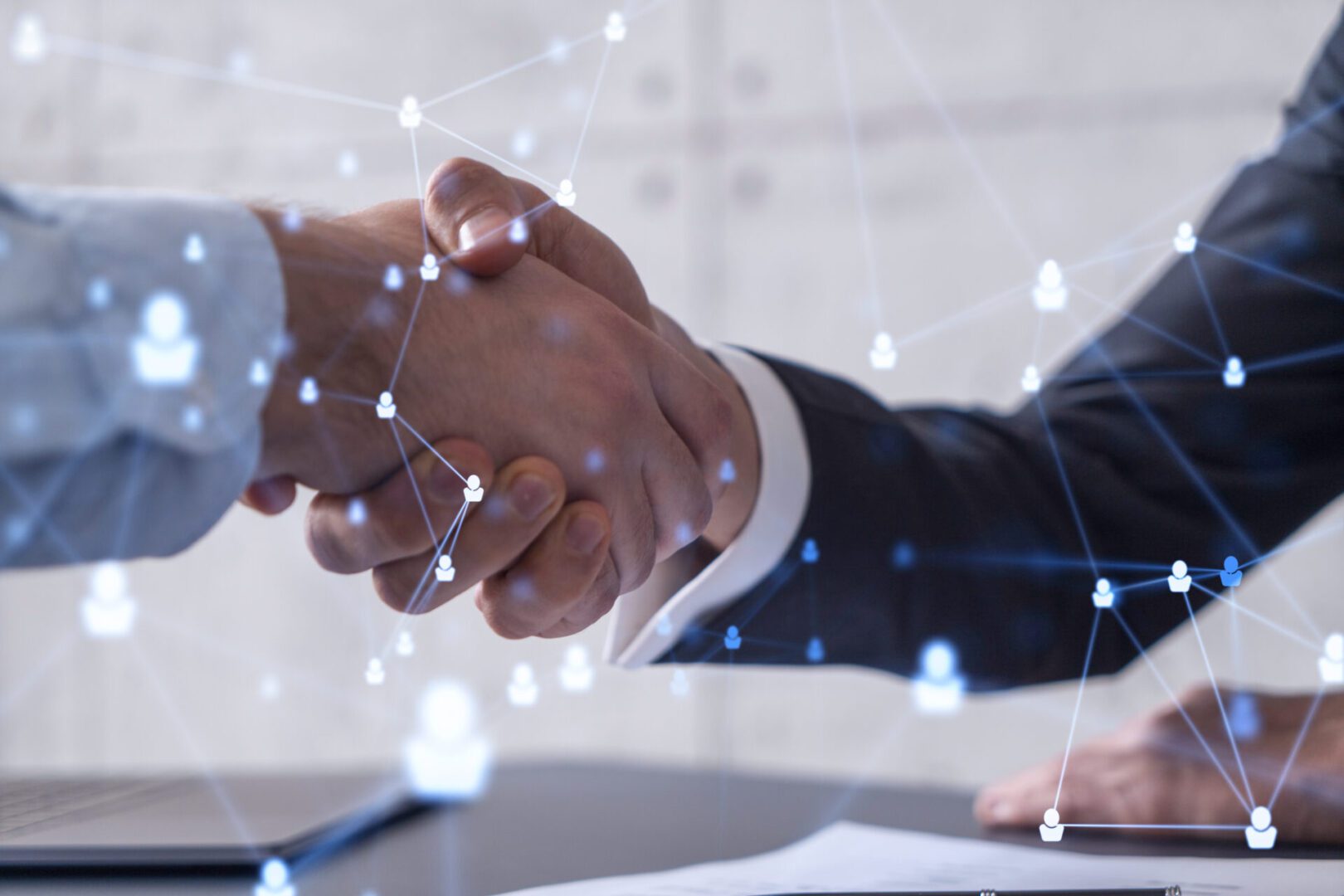 Two professionals shaking hands symbolizing agreement and partnership.