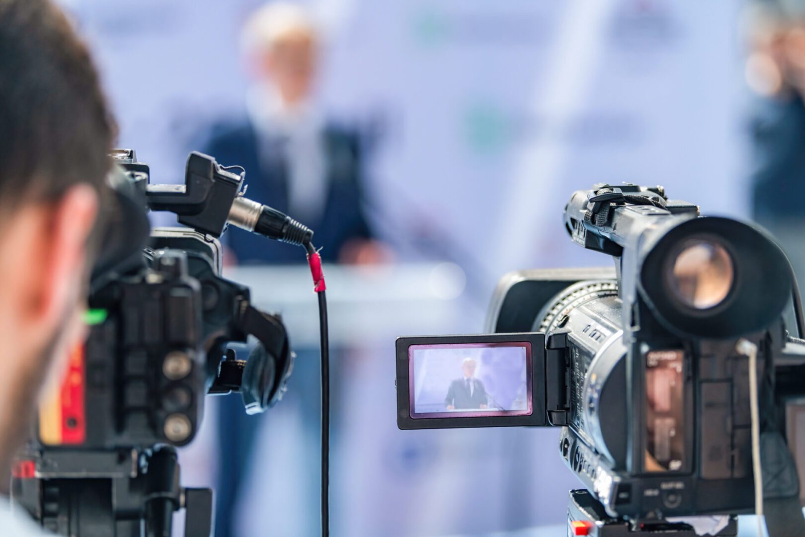 Professional video cameras recording an interview in a studio.